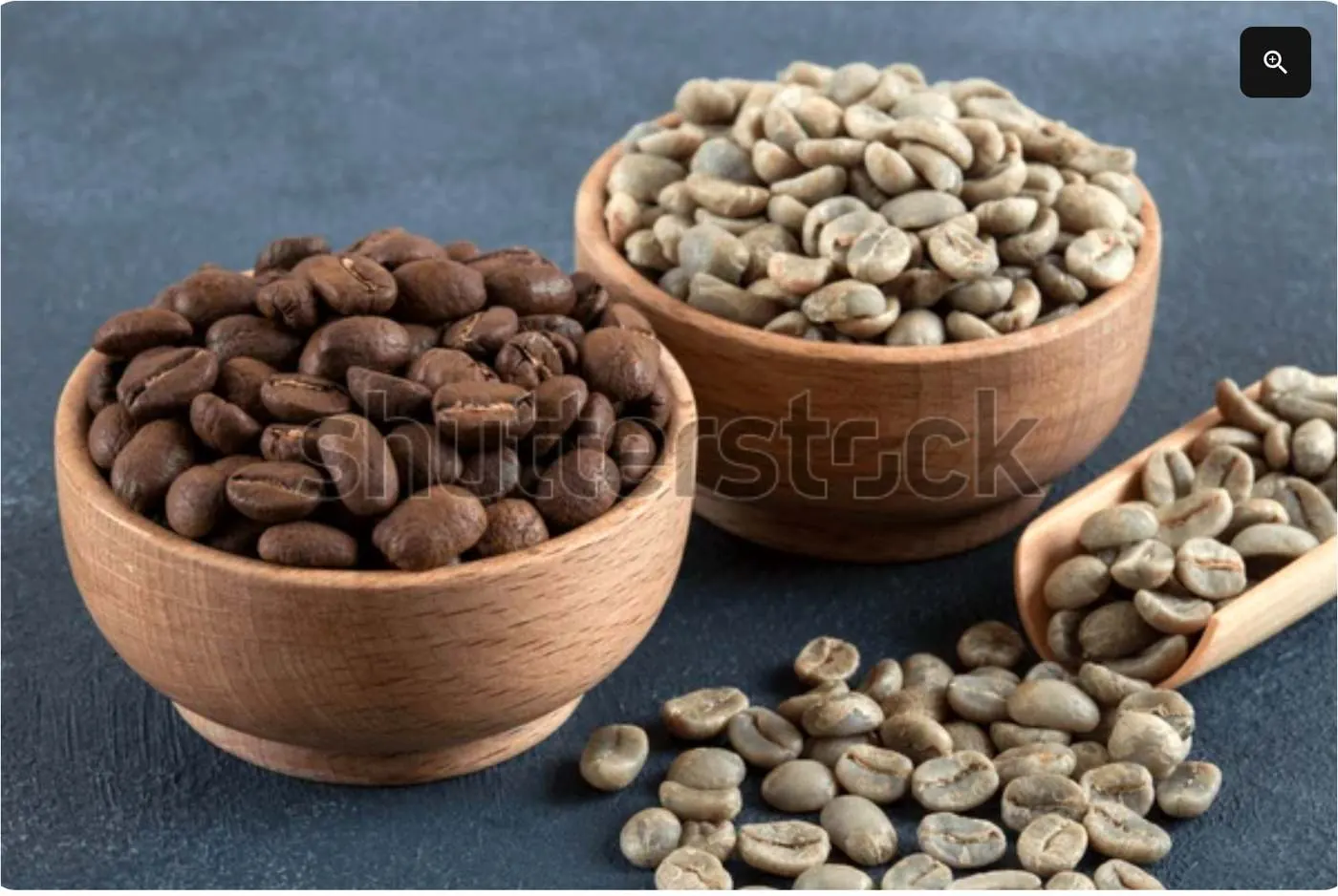Green and roasted coffee beans in wooden bowls